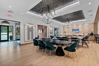 A modern dining room with a large table and chairs.